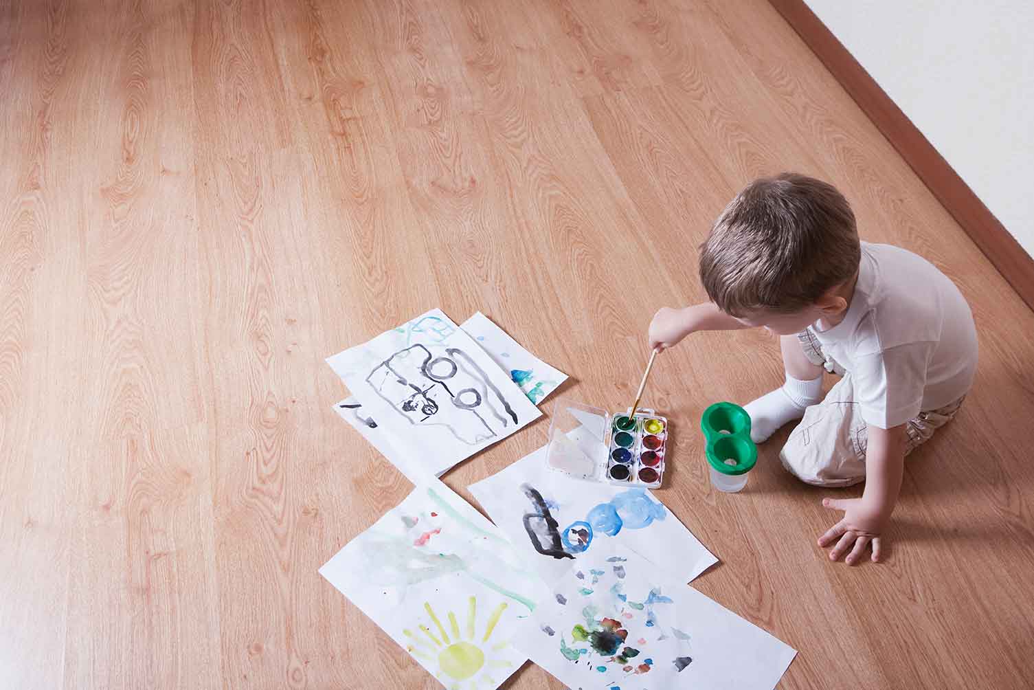 Little boy drawing a picture on the floor | Derailed Commodity Flooring & Furniture