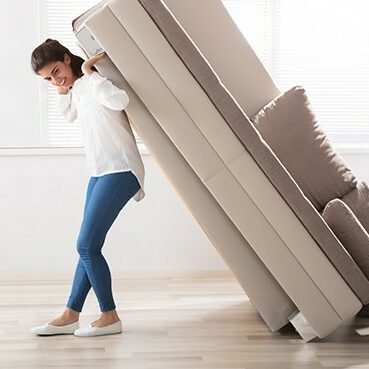 Woman moving sofa | Derailed Commodity Flooring & Furniture